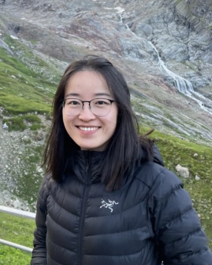 Joi on a mountain path, a glacier valley behind her